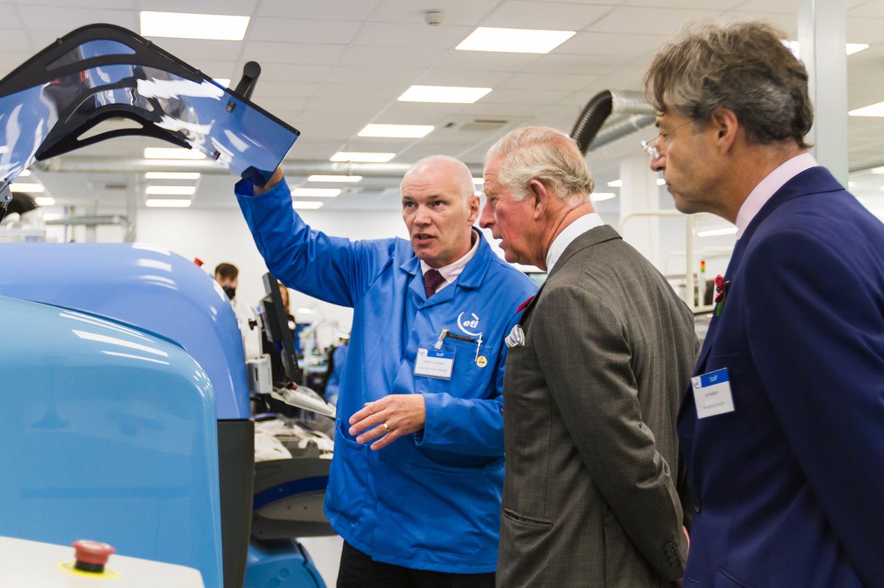 Prince Charles looking at machinery